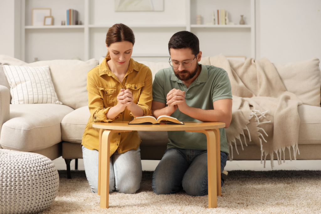 Christian couples prayer community praying together over the Bible